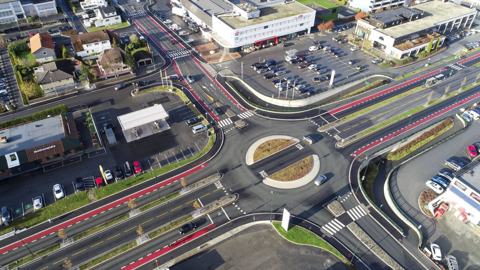 Dronefoto skrått ovenfra over et veikryss med en rundkjøring.