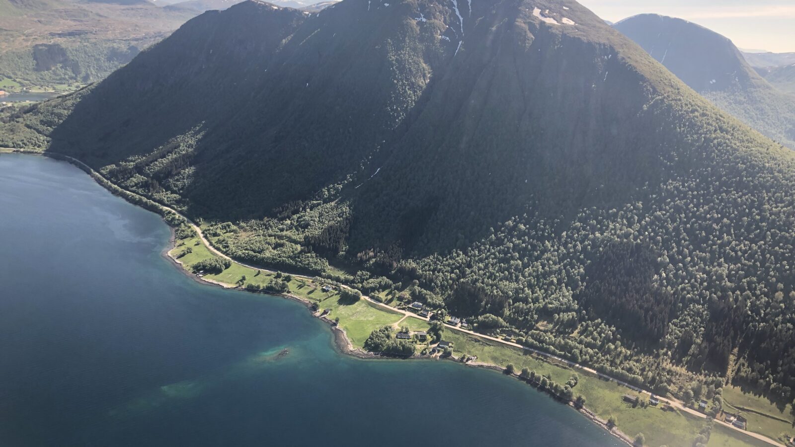 Oversiktbilde over fjord og fjell, tatt fra helikopter
