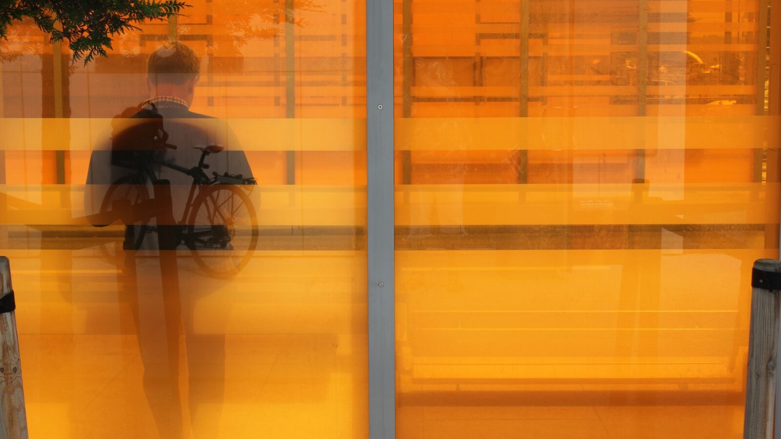 Refleksjon i vindu av mann som venter på kollektivtransport